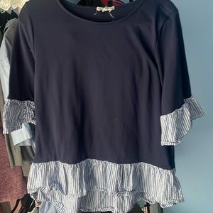 Cute blue sweater material with 3/4 length sleeves high low detail of top.